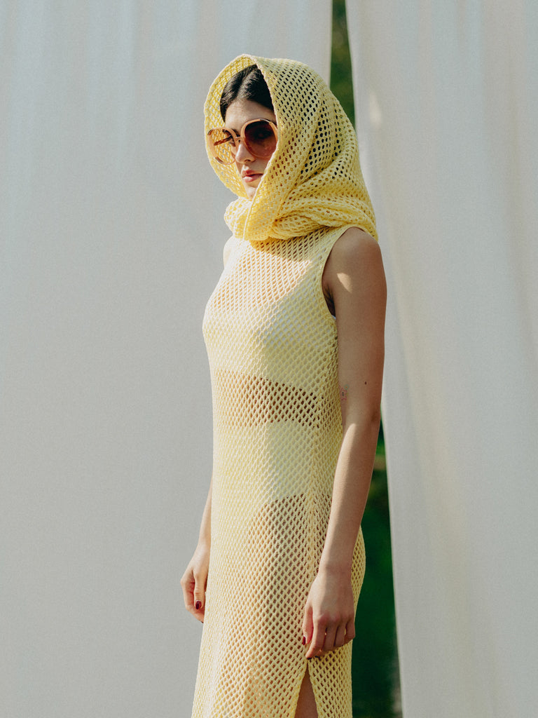 Sassy net knit dress crafted in Switzerland, featuring a classic round neckline, fitting armholes, and stylish side slits, made from organic cotton, perfect for evening wear or summer outings over swimwear